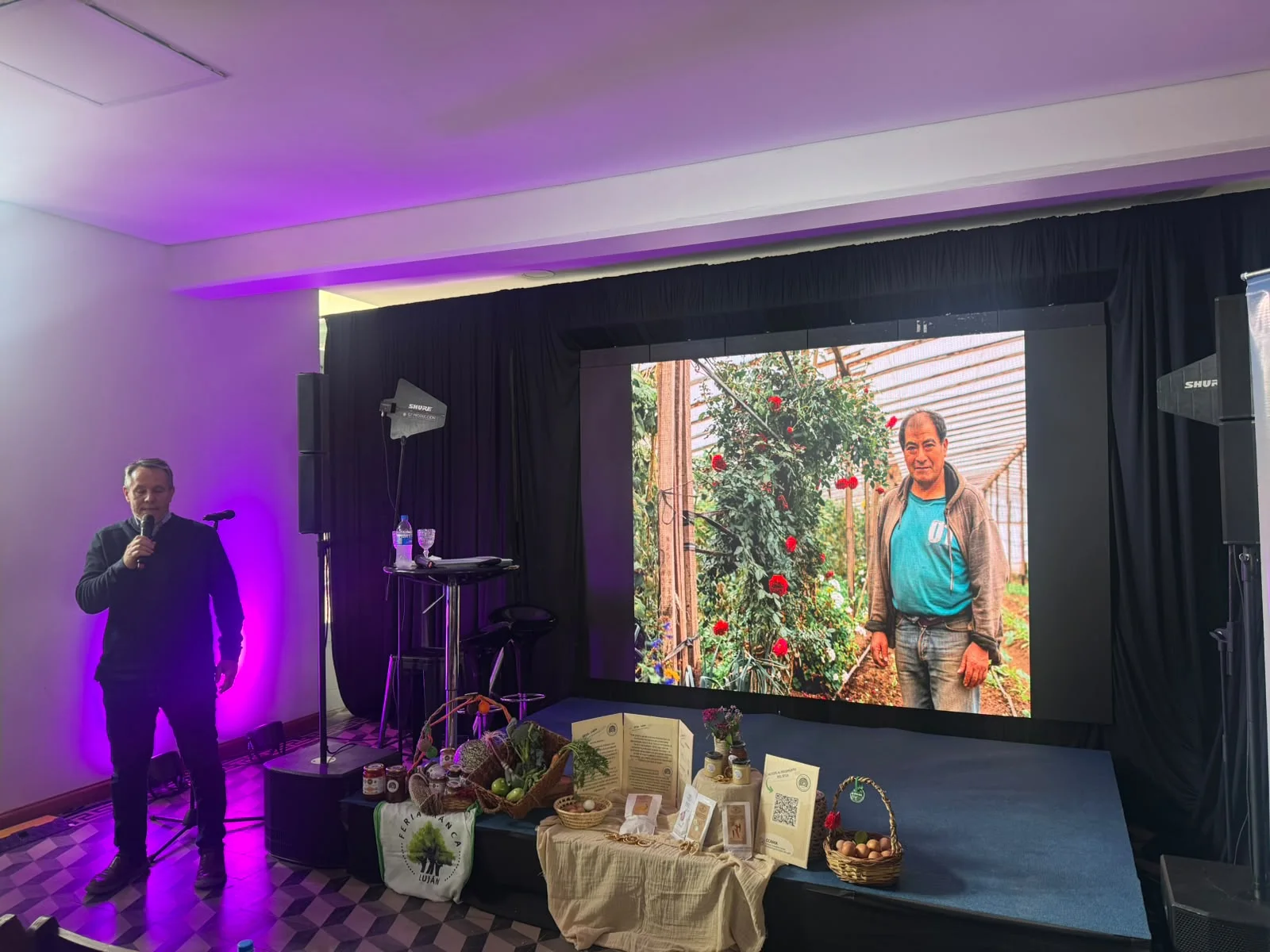 Charla en la Expo Luján Summit 2026, con productos locales exhibidos en el escenario
