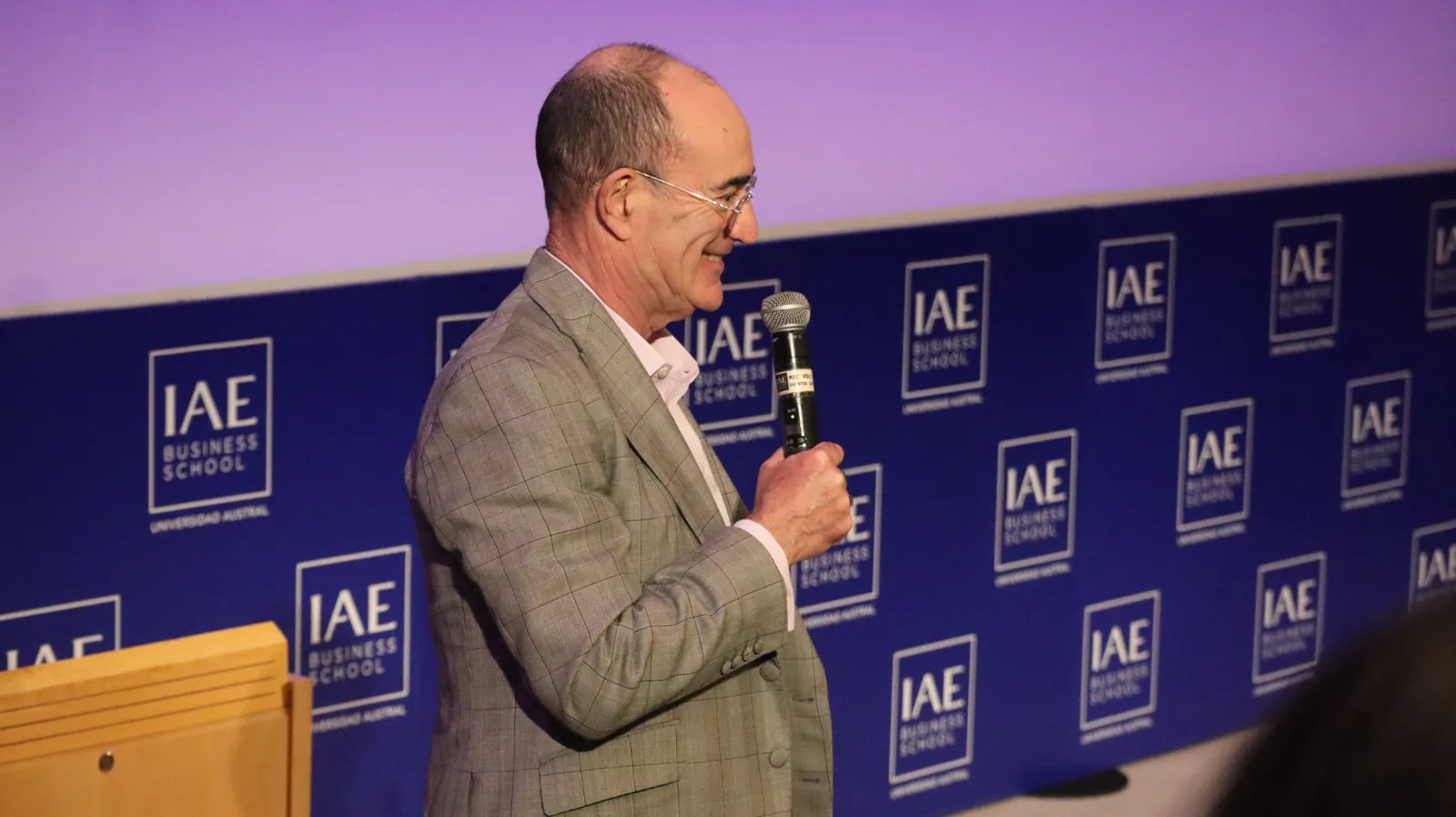 Un expositor habla con micrófono frente al panel del IAE Business School